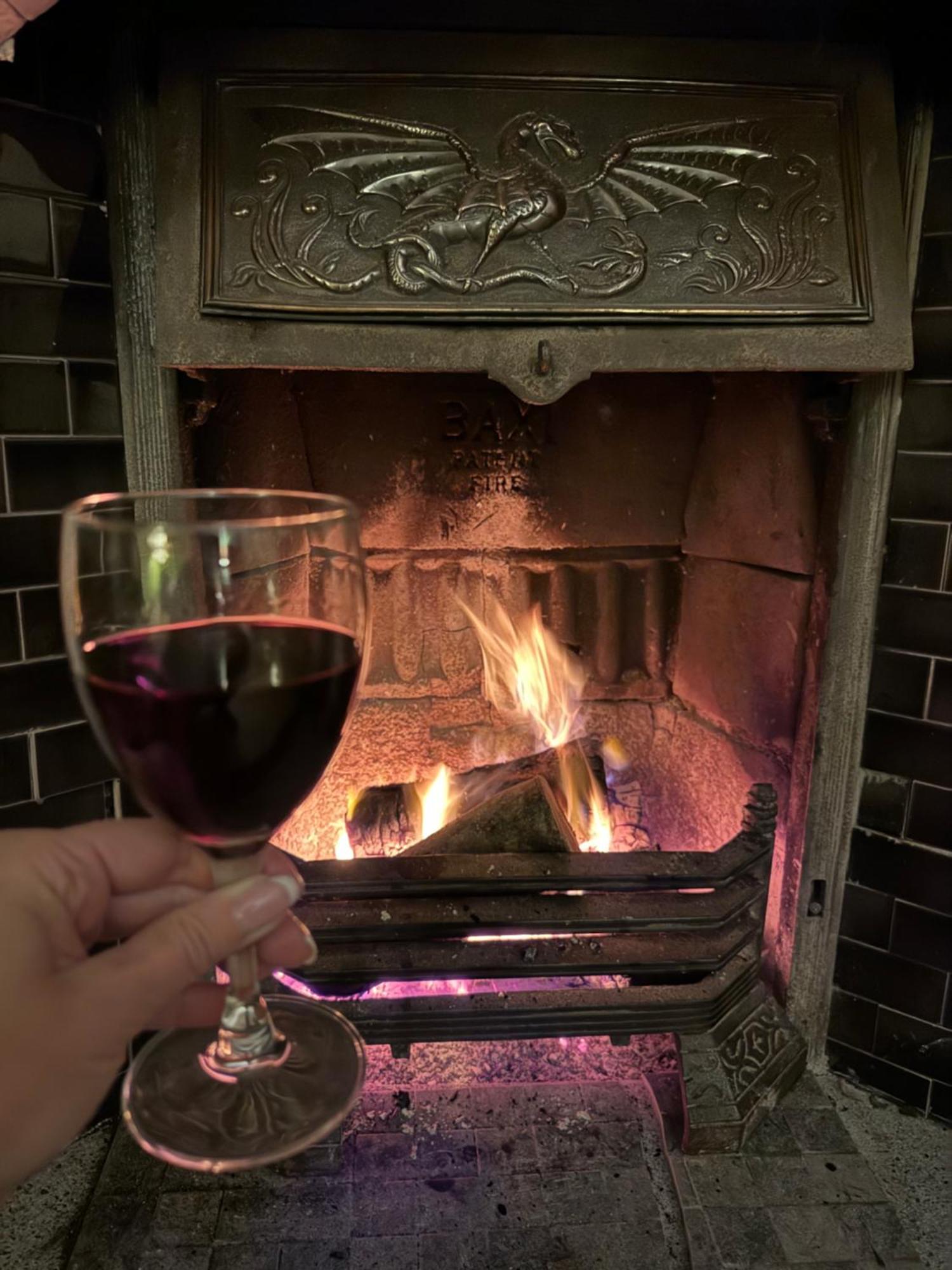 Clone Country House Охрим Экстерьер фото A glass of red wine in front of a fireplace